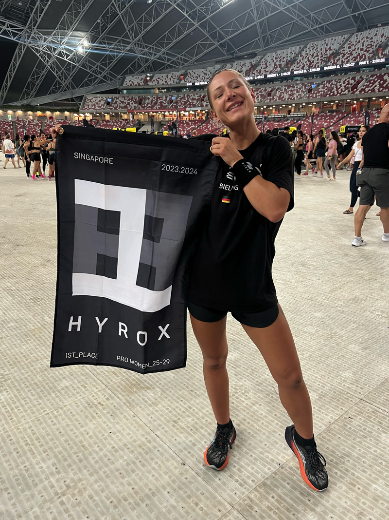 Ein Bild des Trainers, der mit der Hyrox Nr. 1 Flagge posiert.